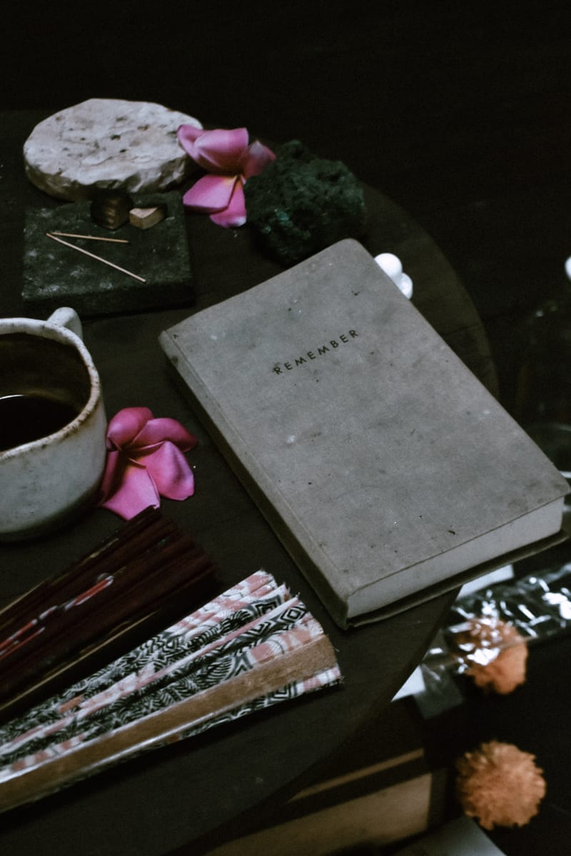 Ein Altar mit verschiedenen Gegenständen wie ein Notizbuch, Blumen, Räucherwerk, ein Fächer